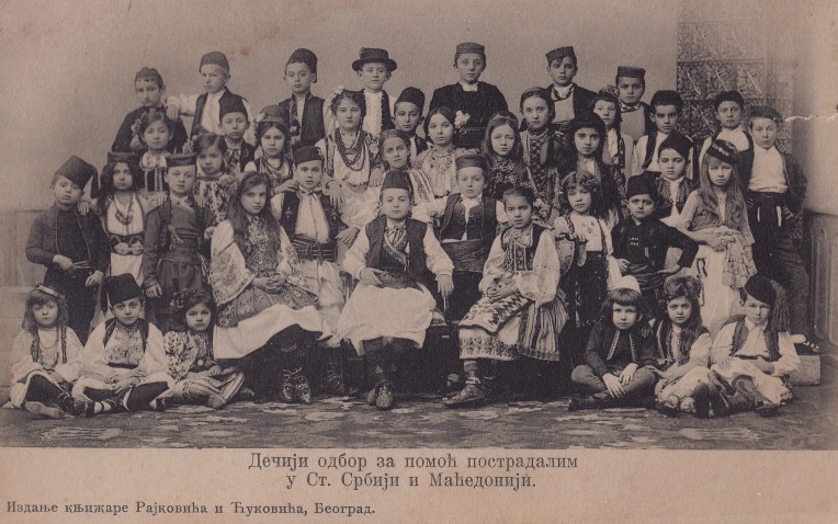 Fundraising postcard of the Children's Committee for Humanitarian Aid of the Children of South Serbia and Macedonia. Centre front is Prince Paul, and to the right (his left) is Ban Nušić, the son of Branislav Nušić. The children are in the various costumes of Yugoslavia, and in the front right corner are a group of children in Cincar/Aromani costume.