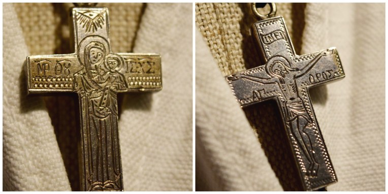Detail of the cross worn with this costume. It is a reliquary cross; that is, it can be opened and inside can be placed a relic of a saint or holy place, or a scroll with a prayer or scripture. It is engraved in Greek, with the Mother of God on one side and the Crucifixion on the other. Flanking the crucifixion is the inscription ΑΓΙΟΝ ΟΡΟΣ, Agion Oros = Mount Athos. This was brought back by an Athonite pilgrim.
